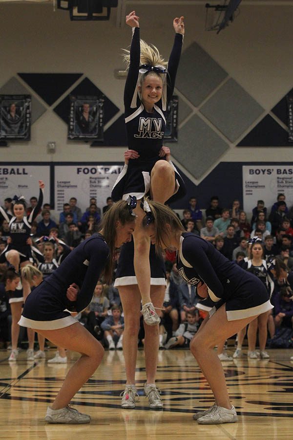 Senior Lexi Moore prepares to jump into a stunt during the cheer routine.