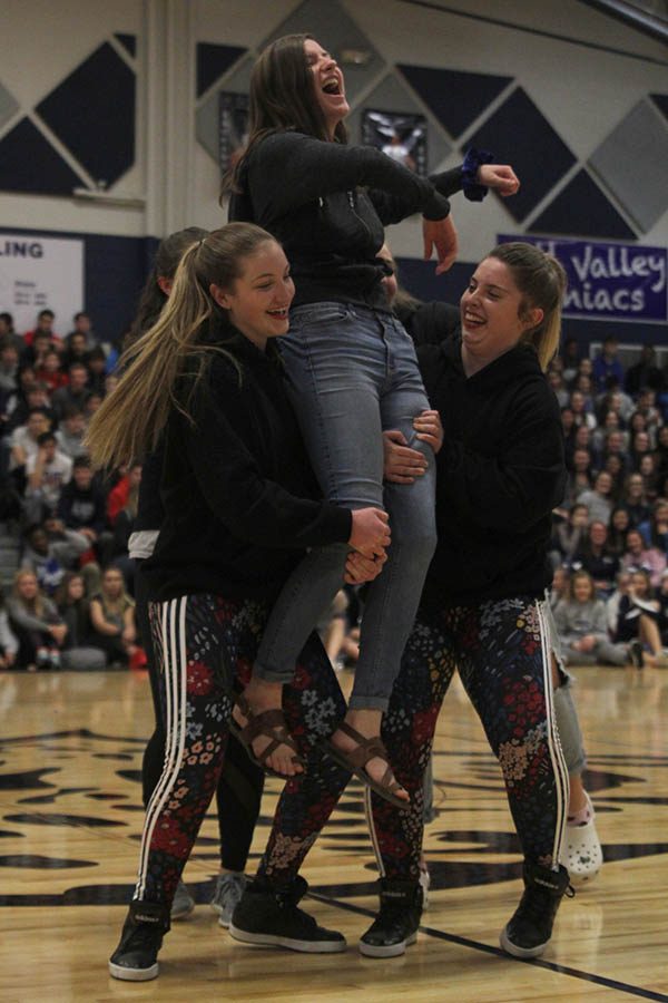 Juniors Abby Sutton and Emma Barge lift up junior Nora Lucas to add emphasis to their routine.