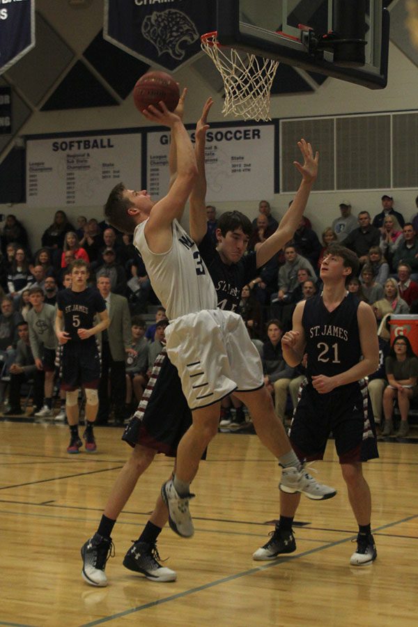 Junior Brody Flamming jumps up to get a basket.