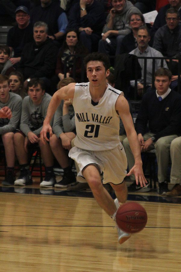 After getting the ball, senior Blake Montgomery dribbles down the court.