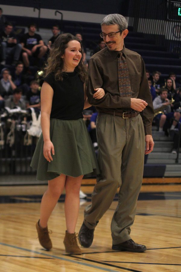 Senior Melissa Kelly smiles with her dad while walking down the court.