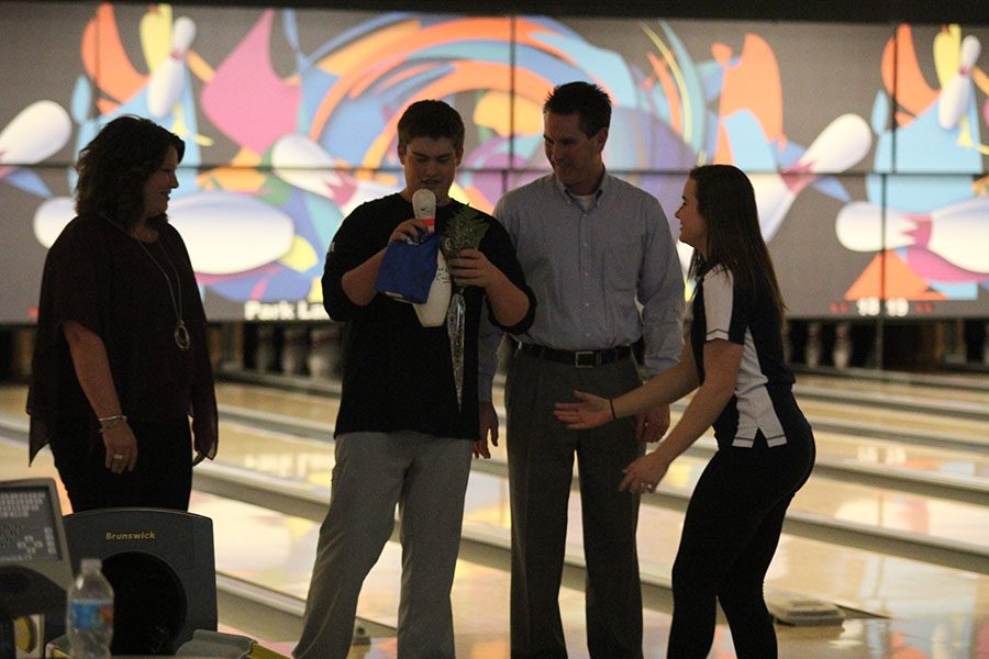 Senior Jesse Bowden gladly accepts his bowling pin with his parents by his side.