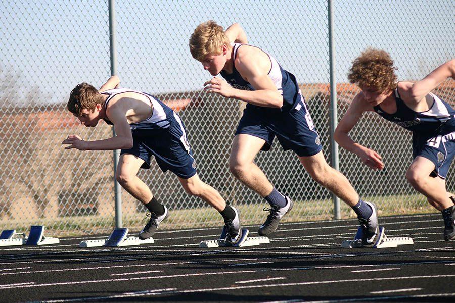 Freshmen Jace DeWitte (right), Kyle Kelly (middle) and Logan Oesterreich (left) compete in the 100 meter dash.