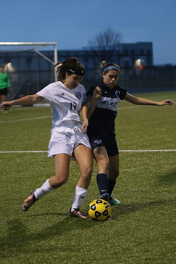 Junior Kylee Melendez reaches out with her foot to take the ball from another player.