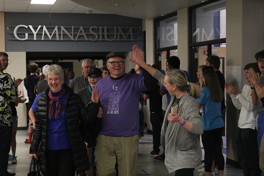 During the survivor walk, spanish teacher Siri Campbell high-fives her father, cancer survivor Jon Hanson