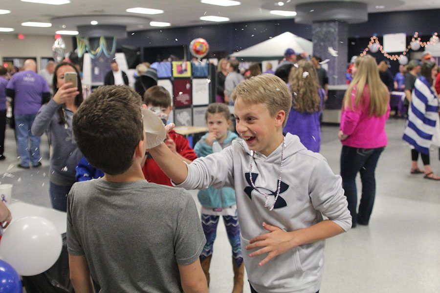 Middle schooler Alex Shank smashes a cream pie in his friends face as part of a c Relay booth.