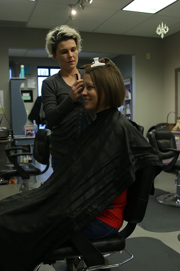 English teacher Ashley Agre gets her hair dyed purple after reaching $50,000 goal.