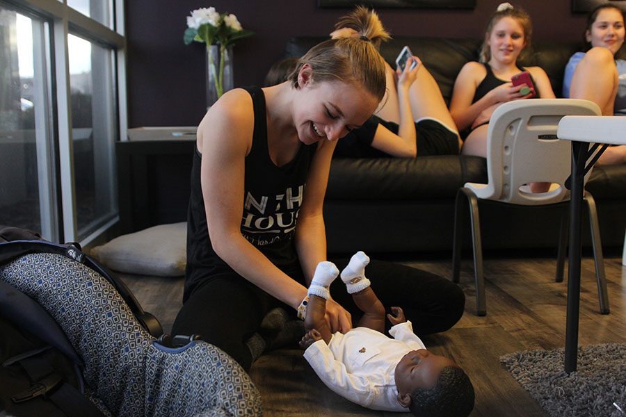 At Perception Dance Company, sophomore Megan Bryant changes the diaper of her baby for her Human Growth and Development project on Sunday, Jan. 29. “The nights were hard and I didn’t get a lot of sleep some nights,” Bryant said. “When I went out with the baby I loved it when I got comments on the baby. I also just love kids so this was just fun for me.” 