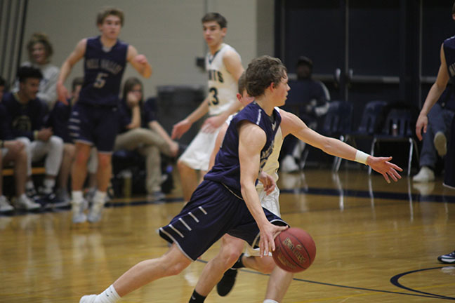 Sophomore Tanner Moore dribbles the ball down the court.