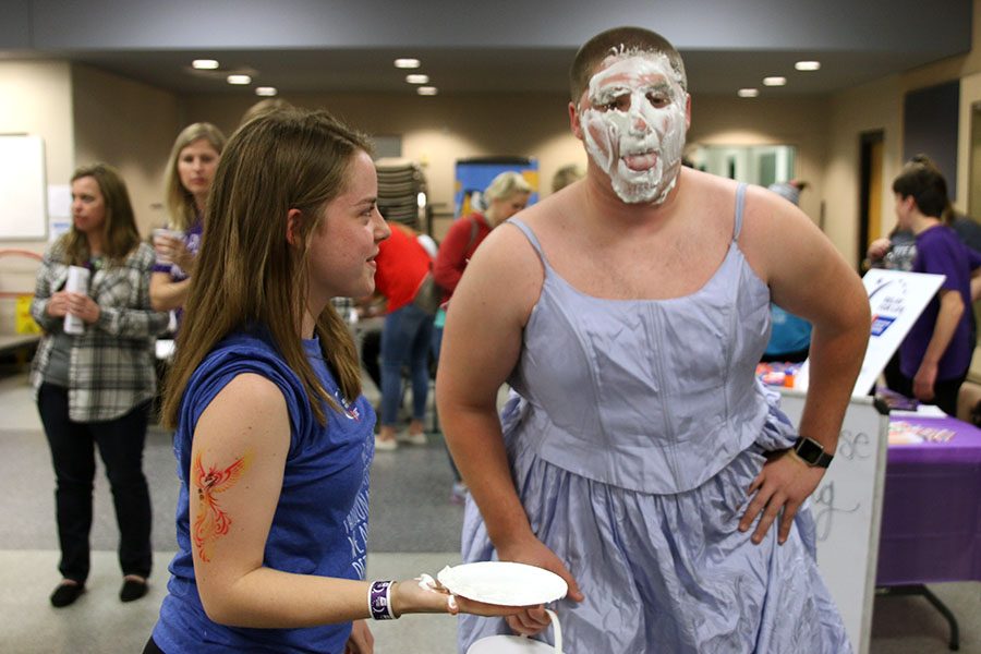 Junior Allison Lust hits senior Jacob Campbell in the face with a pie during their participation in team fundraising activities.