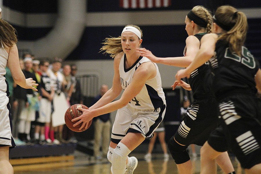 Grabbing the ball, junior Evan Zars runs down the court during first quarter on Wednesday, March 1 against Blue Valley Southwest. 