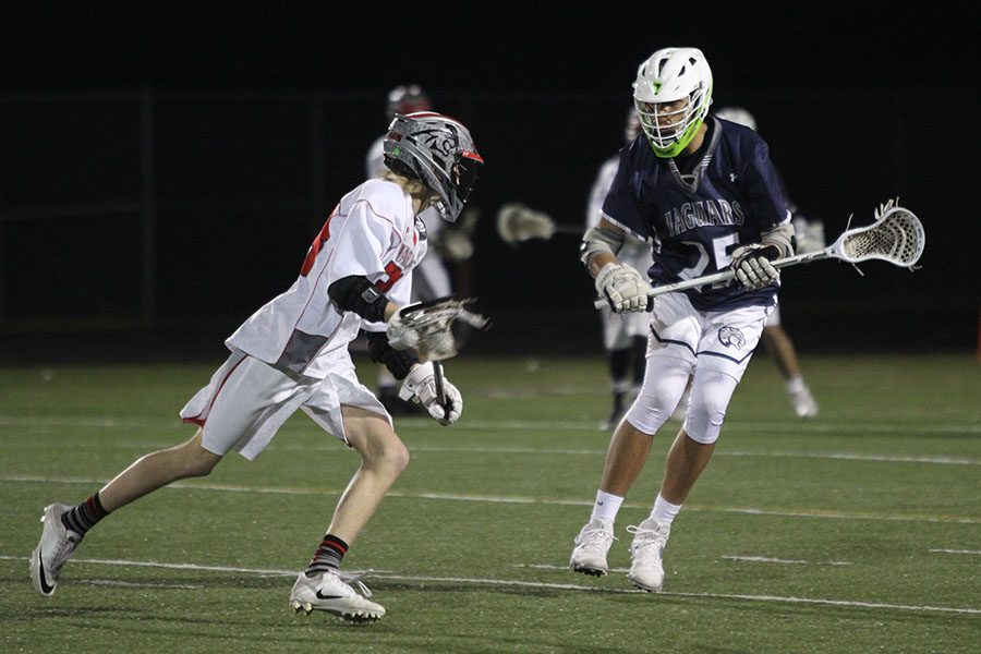 The Jaguars fall to Blue Valley West 12-3 on Friday, March 24. Keeping his eyes locked on the ball, sophomore Seth Hobson defends his opponent.