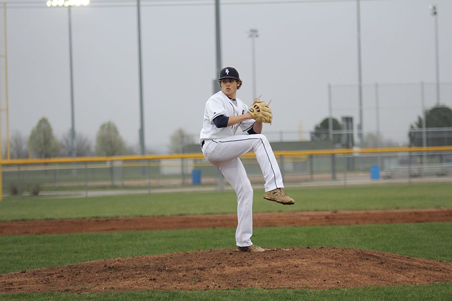 Pitching the ball, senior Dawson Cantwell kicks up his leg.