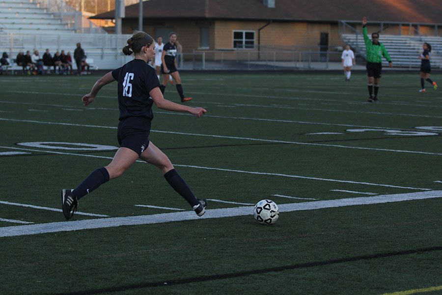 Running forward, junior Cori Carver prepares for her penalty kick.