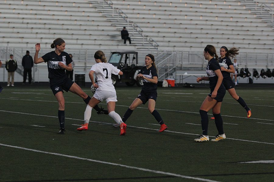 Girls soccer players encircle Blue Valley during the first half.