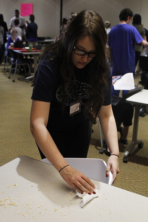 Junior Emily Wagner cleans off a table during the setting/bussing event.