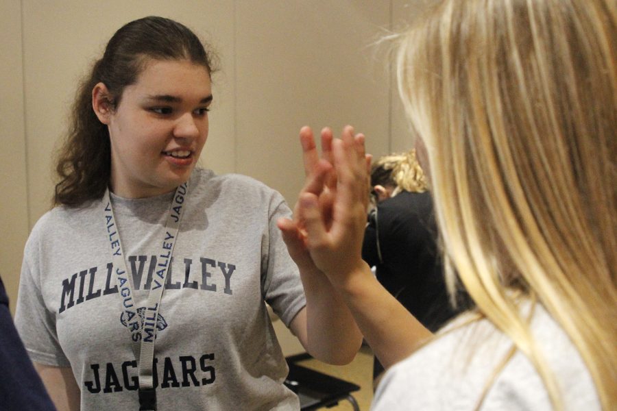 Junior Abby DeBrabander gives senior Sidney Lawyer a high five after competing in sorting silverware.