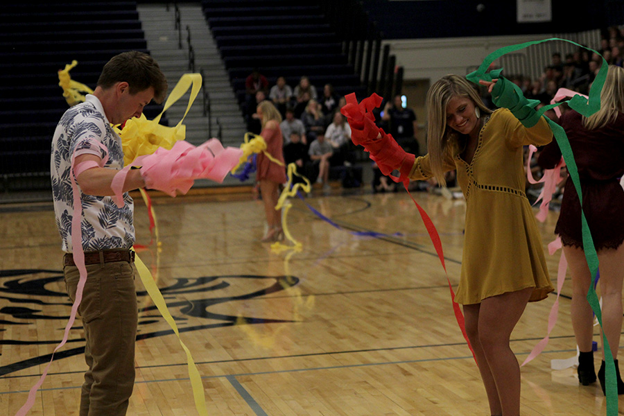 Wrapping their arms in streamers, seniors Austin Garner and Sidney Lawyer compete in the prom candidate games.