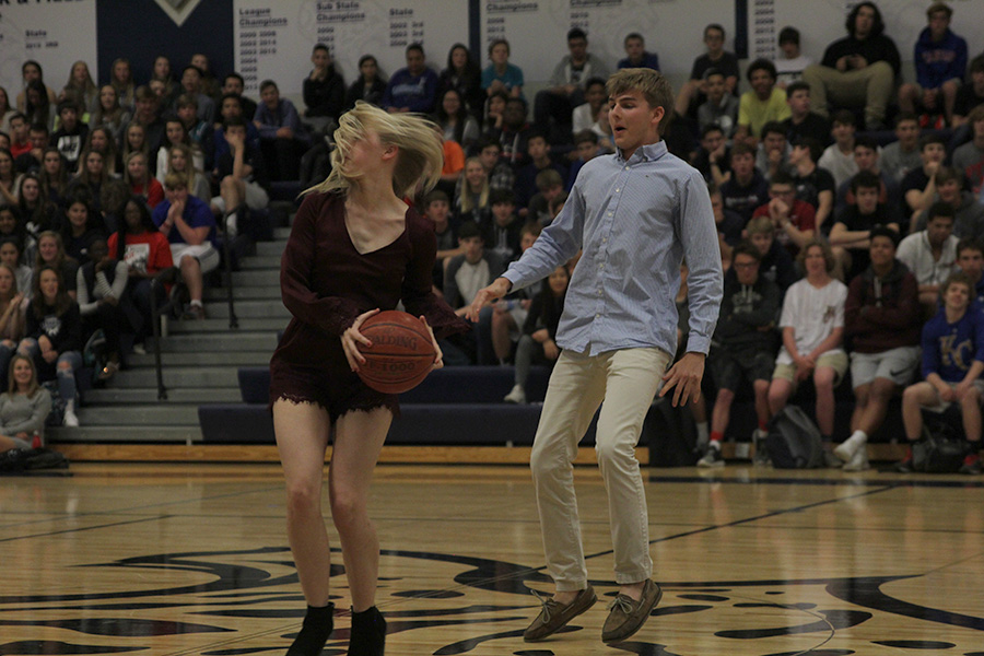 Juking senior Aaron Kofoids out, senior Lexi Moore spins with a basketball as a part of their prom candidate introduction.