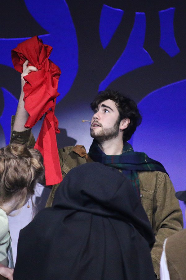 The Baker, played by junior Simon Stewart, hold up the red cape to feed to the cow.