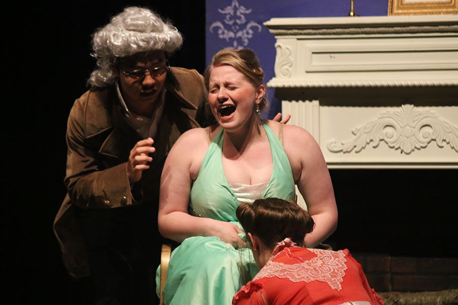 Cinderella's Stepsister, played by senior Kaylie McLaughlin, tries on Cinderella's golden slipper.