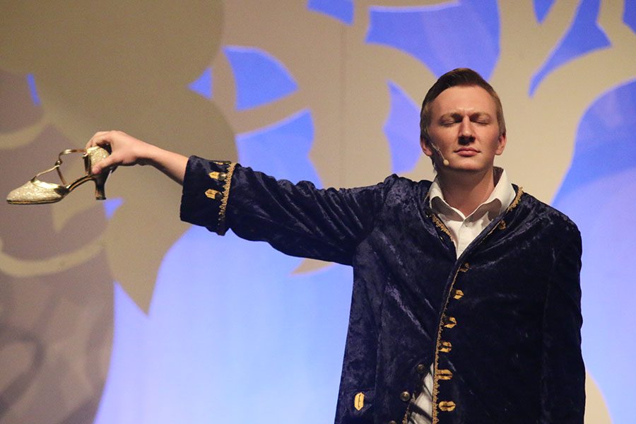 The Prince, played by senior Brady Rolig, holds out Cinderlla's golden slipper.