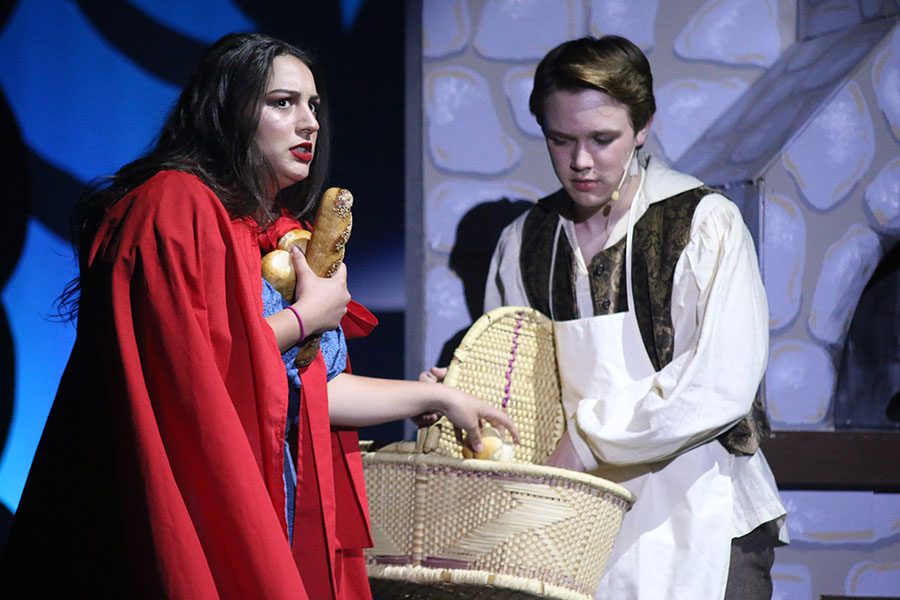 Little Red Riding Hood, played by junior Natasha Roh, puts bread into a basket given to her by the Baker, played by junior Tyler Orbin.