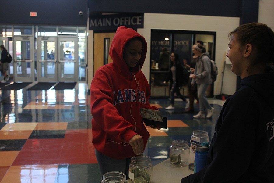 Junior Camryn Coleman donates to the NHS coin drive. 