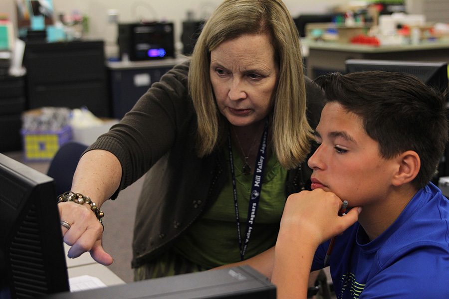 Showing a student how to work the computer program Inventor on Wednesday, April 19, engineering and technology teacher Gayle Kebodeaux points to a tool on the drop down menu bar. “Technology is a huge piece [of my class] because it is so important in the world now,” Kebodeaux said. “This is a class where you can explore how technology works because we use the computer every day along with the 3-D printers, laser engravers and mills.”