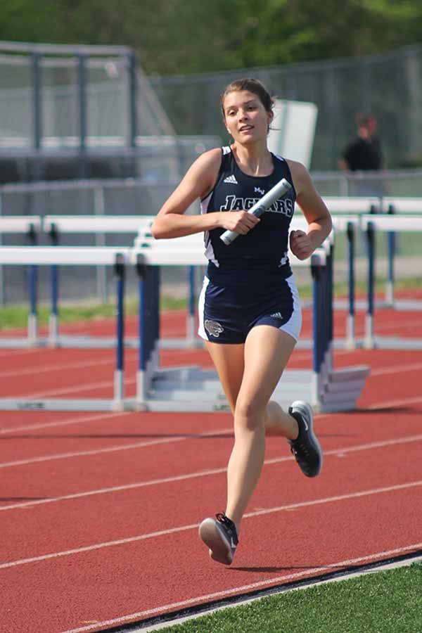 In the 4 by 8 relay, Brynn Rittenhouse sprints with baton in hand.