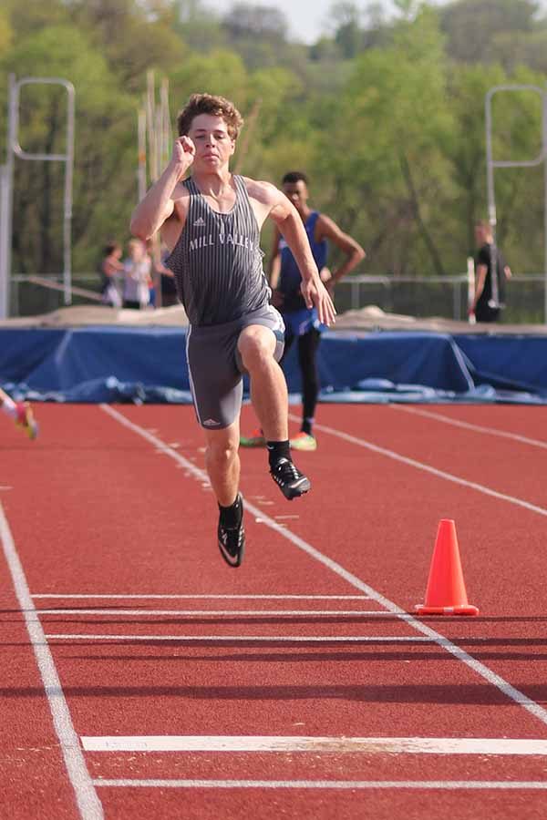 Running toward the sand pit, sophomore Steven Colling explodes through his final phase.