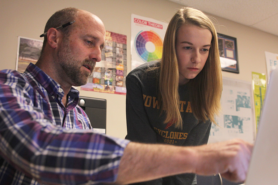 While helping senior Raya Lehan on a project, Graphic Design teacher Jerry Howard explains what Lehan did well with her project on Monday, April 24. “On blue days, I have an amazing group of independent study kids come in and share my plan with me,” Howard said. “I try my best to stay out of what they’re doing but sometimes it’s hard. [My favorite part is] when they come over and ask my opinion on what they’re working on.”