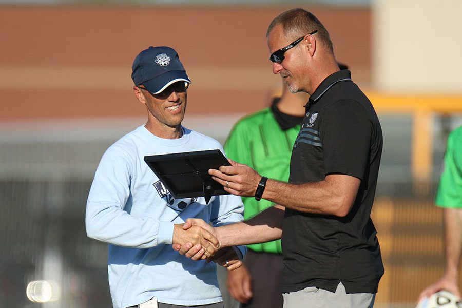 Before the girls soccer game on Tuesday, April 18, head coach Arlan Vomhof receives a plaque  honoring his 400th coaching victory from athletic director Jerald VanRheen.