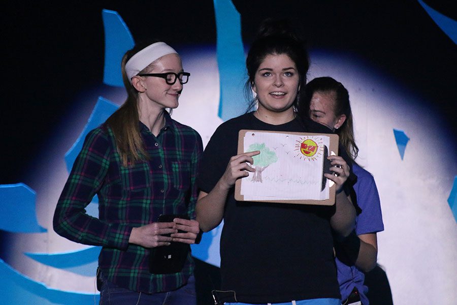 "Nerd," played by junior Elaina Smith, holds up a drawing of the weather.