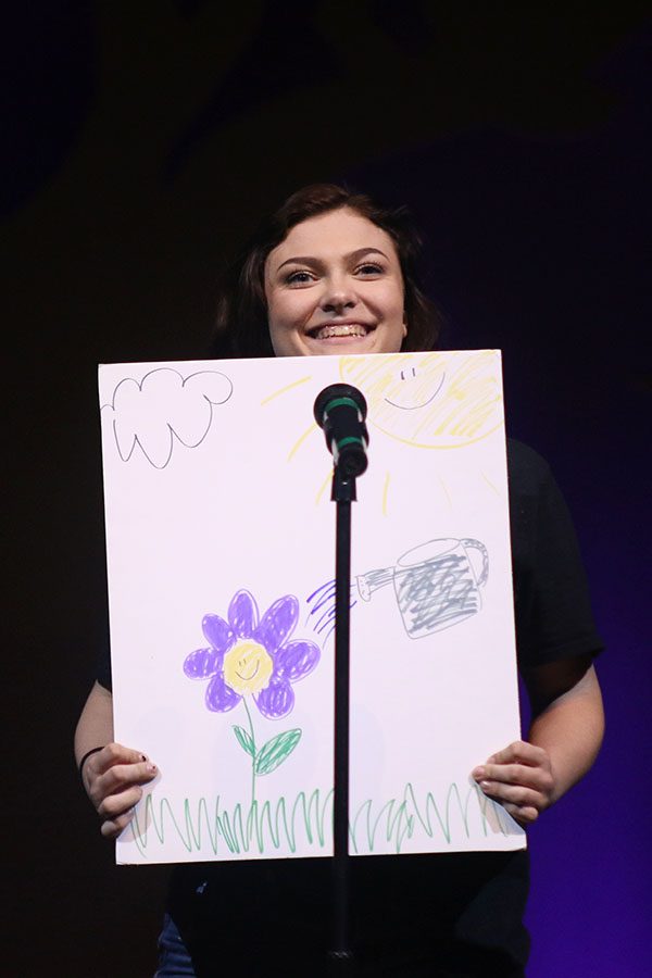 Jane, played by junior Jessie Haase, holds up a poster about the Earth.