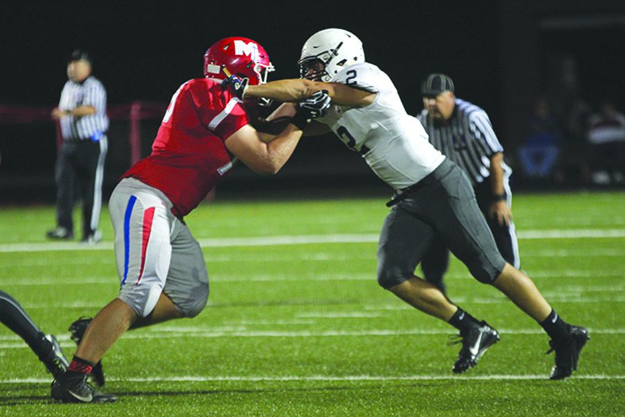 With his hands on his opponent's shoulders, junior Ike Valencia pushes the Bishop Miege player back on Friday, Oct. 7. The Jaguars fell to Bishop Miege 64-21.