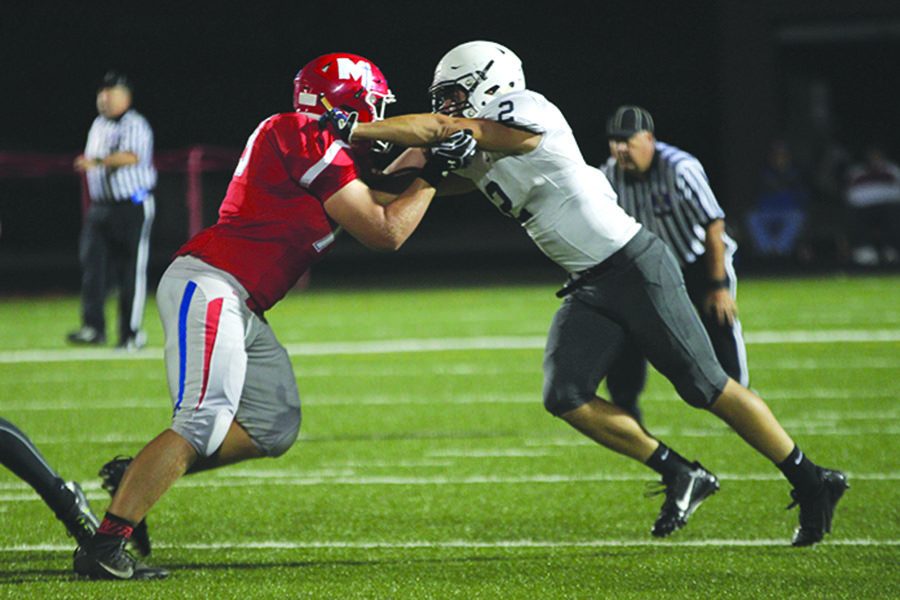 With his hands on his opponents shoulders, junior Ike Valencia pushes the Bishop Miege player back on Friday, Oct. 7. The Jaguars fell to Bishop Miege 64-21.