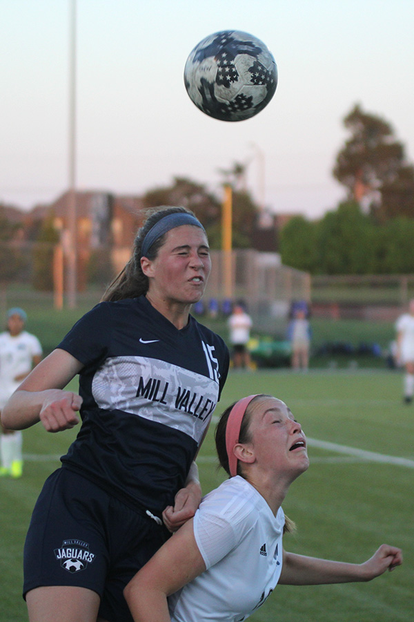 Jumping over her opponent, freshman Lanie Whitehill prepares to receive the ball using her head.