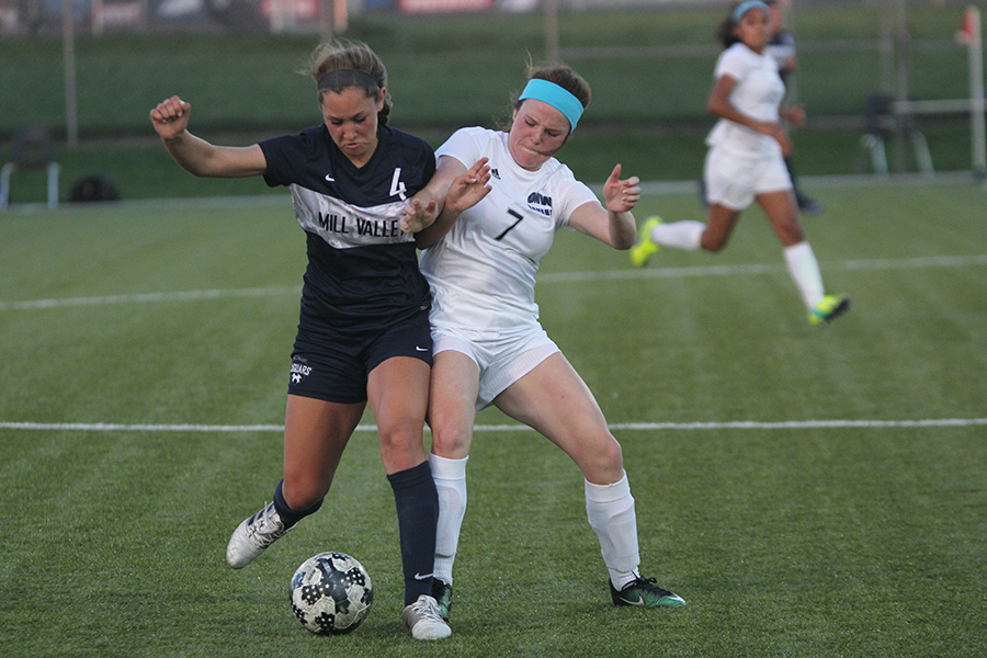 Freshman Ella Shurley fights with a player from Olathe Northwest for the ball.