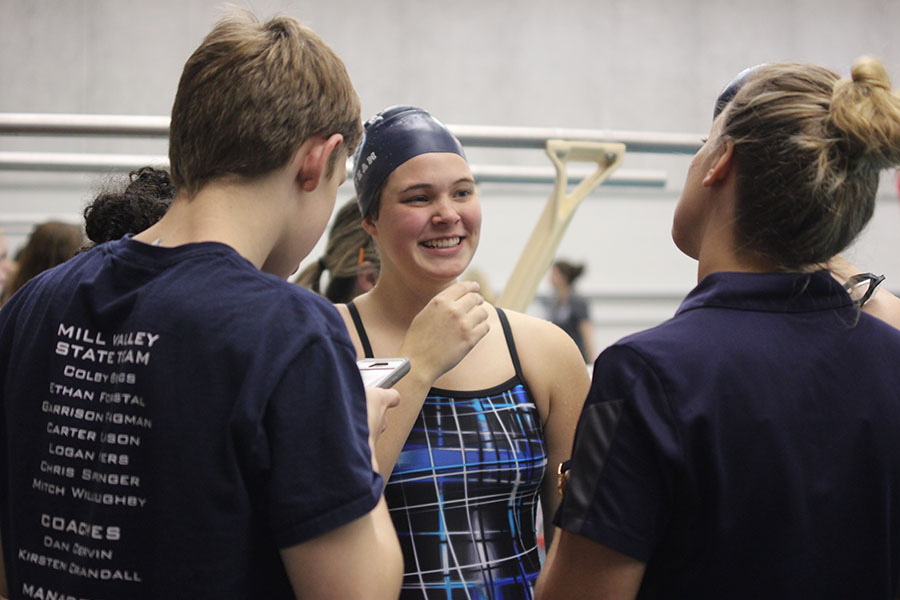 In between swimming, junior Victoria Wright talks with sophomore Chris Sprenger and coach Kirsten Crandall.