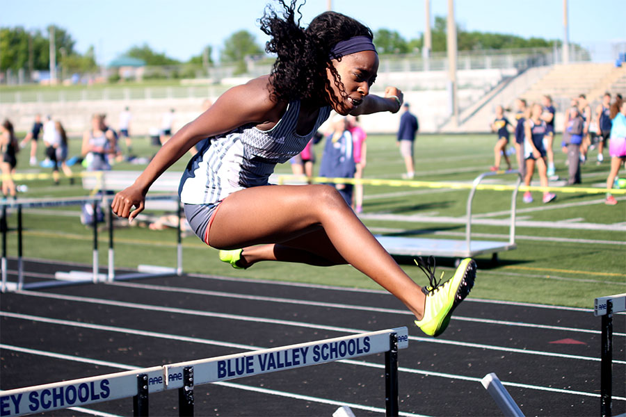 Jumping in the air to get over a hurtle  senior Nicole Lozenja competes in the 100 meter hurtles    