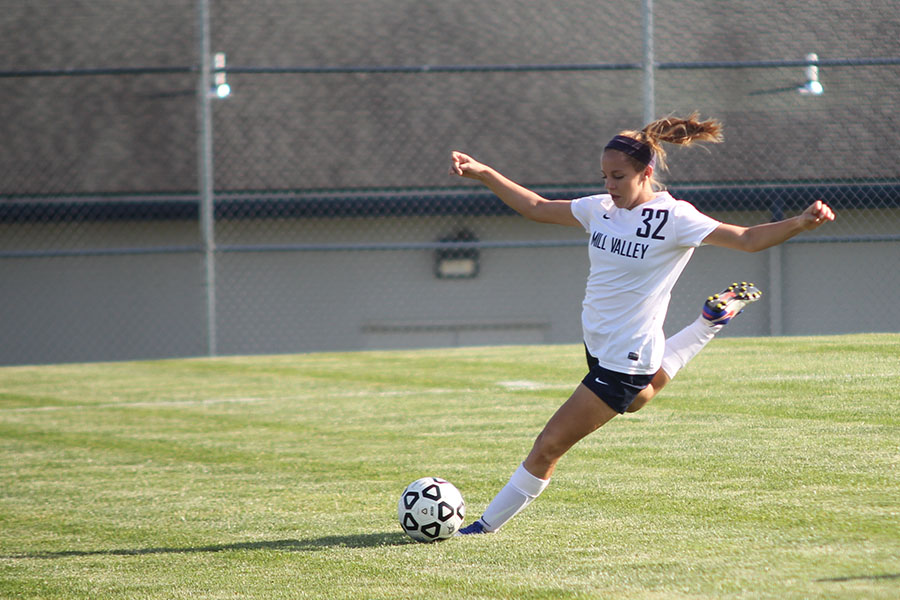 Sophomore Caroline Rutledge prepares to kick the ball to an open player.