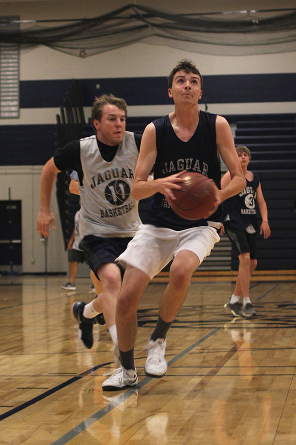 With a social studies teacher Ian Nichols on his tail, senior Drew Fauth goes for a layup. 