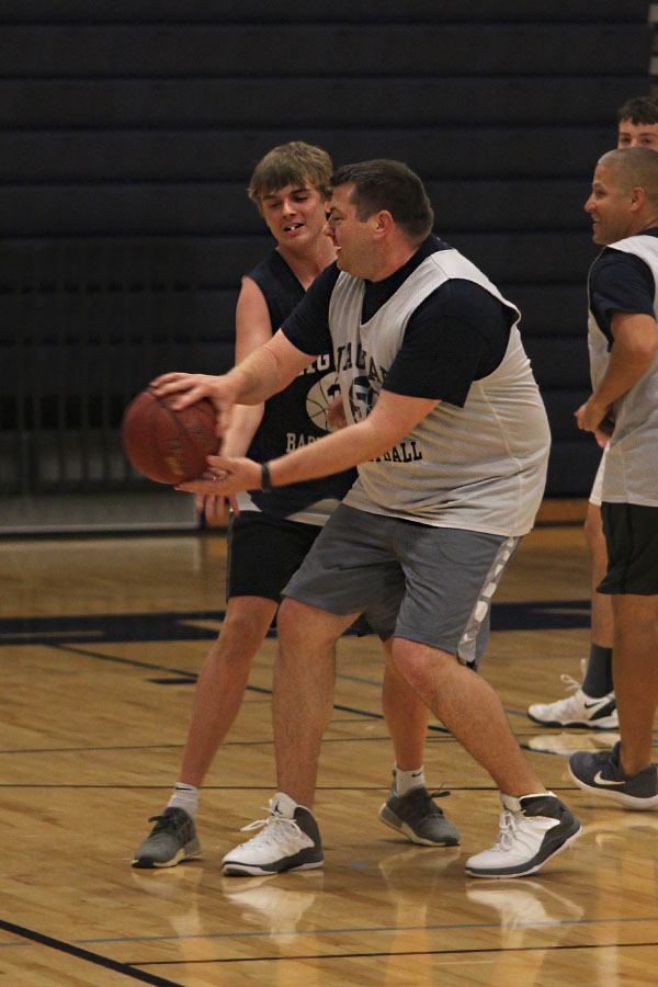 With senior Jack Cooper next to him, math teacher Alex Houlton holds the ball. 