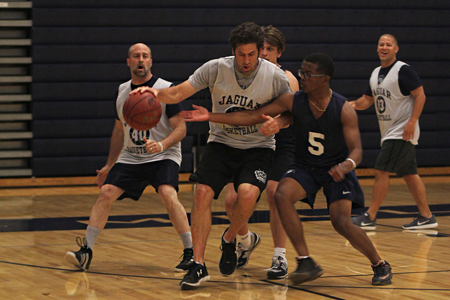 With English teacher Mike Strack in possession of the ball, senior Josh Hill attempts to steal it on Tuesday, May 9. The students lost to teachers 40-37. 