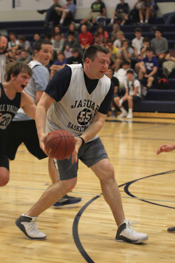 With senior Chris Weber following close behind, math teacher Alex Houlton prepares to pass the ball.