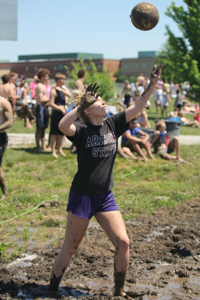 Serving the volleyball, senior Emma Mantel participates in mud volleyball on Saturday May 13.