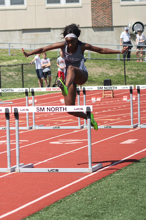 With her arms stretched out, senior Nicole Lozenja leaps over the second hurdle.
