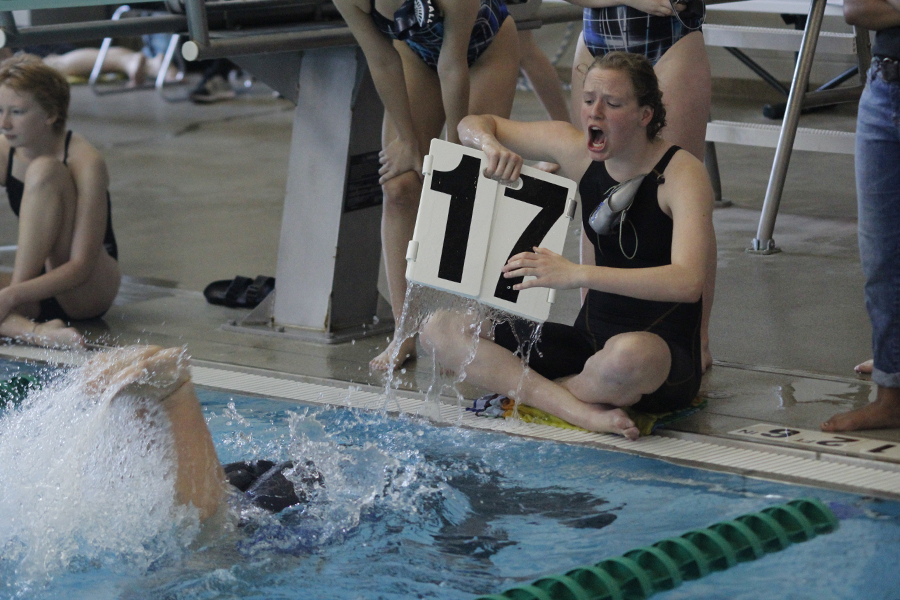 Freshman Kayla Teasley cheers and counts laps for her teammate during the 500 yard freestyle,