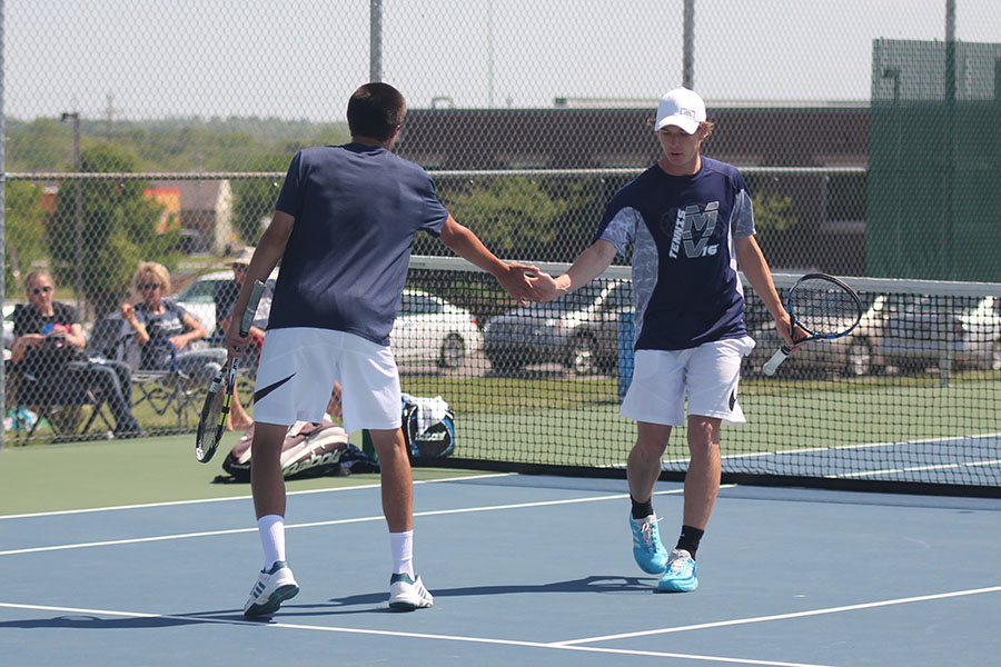 Senior Alec Bergeron high fives his doubles partner after scoring a point. 